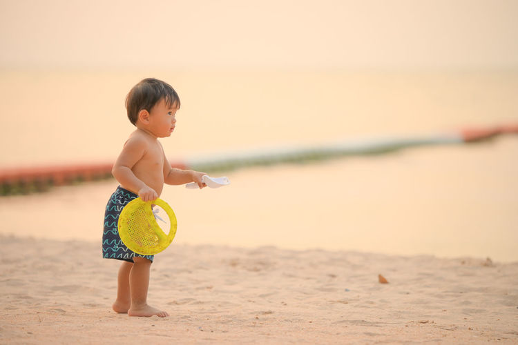 Boy playing with toy on beach