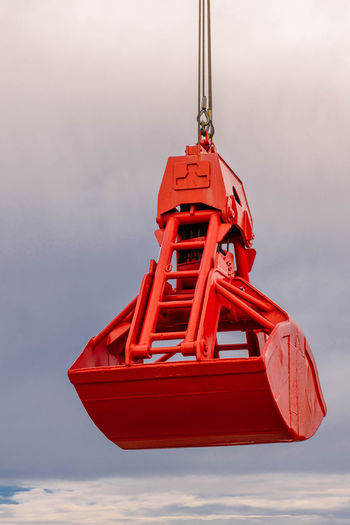 Close-up of red boat hanging against sky