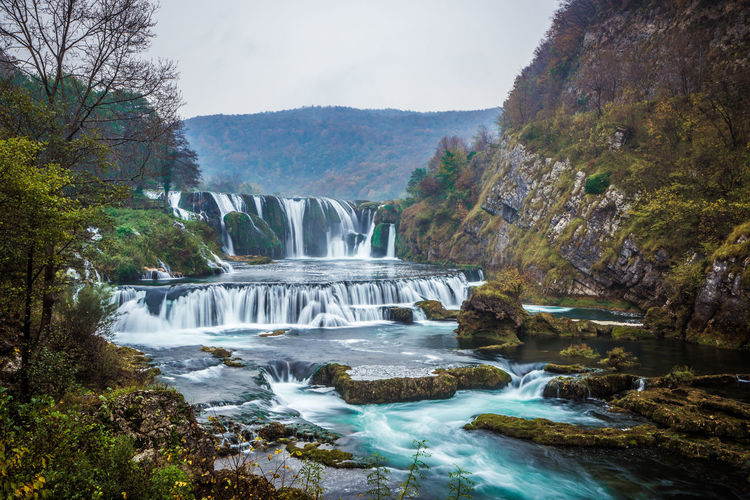 Scenic view of waterfall against sky