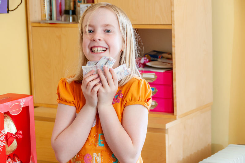 Portrait of smiling girl holding indoors at home