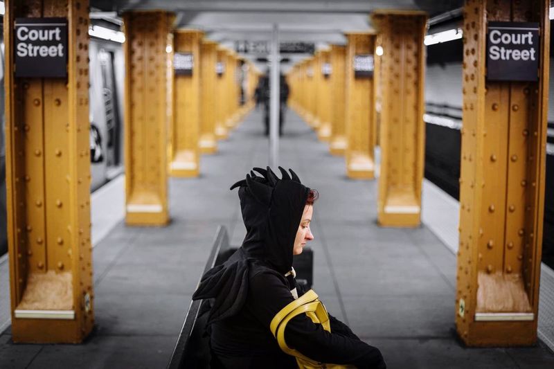 Young woman in costume waiting at subway station