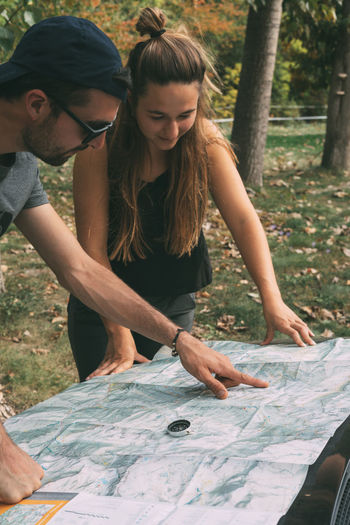 Boy and girl planning the route on a map and a compass