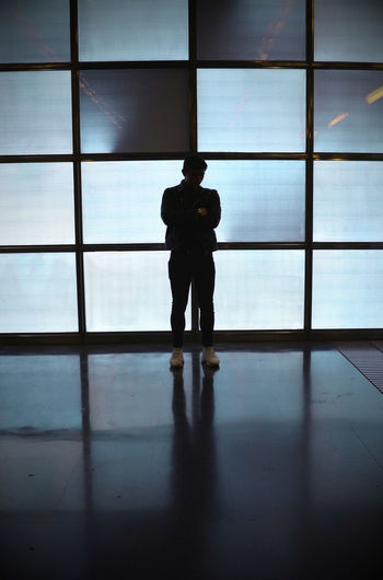 Silhouette man standing on window