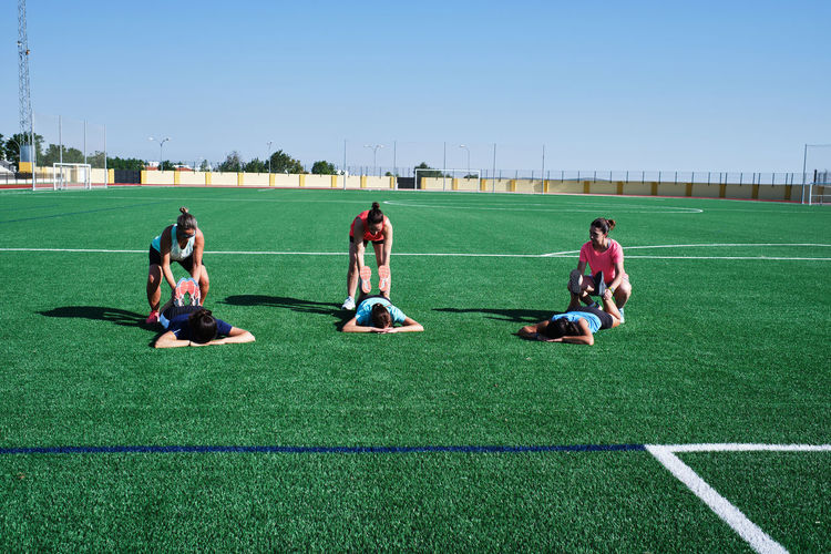 Group of young women practice stretching after their training