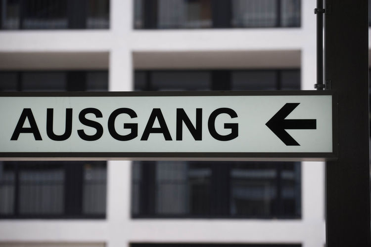 Black and white exit - ausgang - sign with arrow pointing to the left