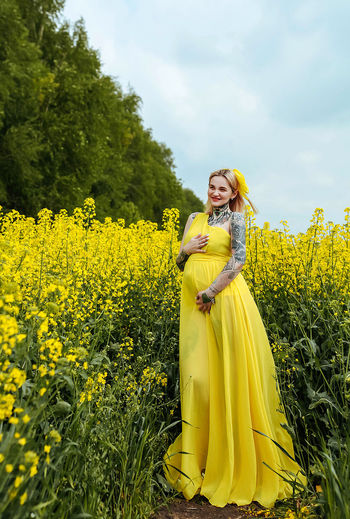 Portrait of pregnant woman standing in farm