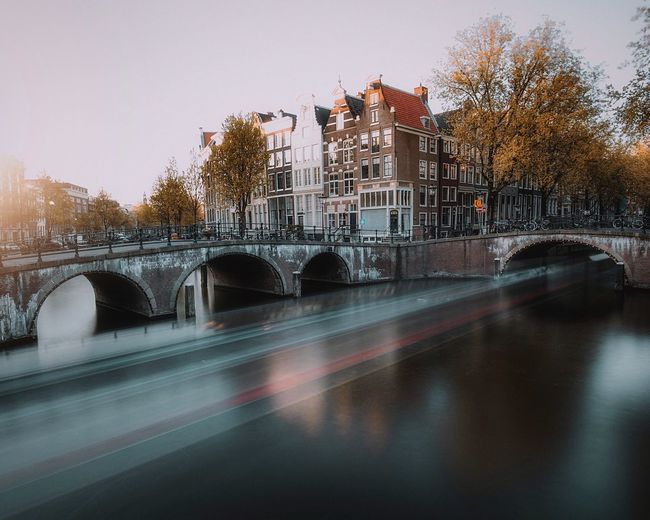 Bridge over river against buildings in city