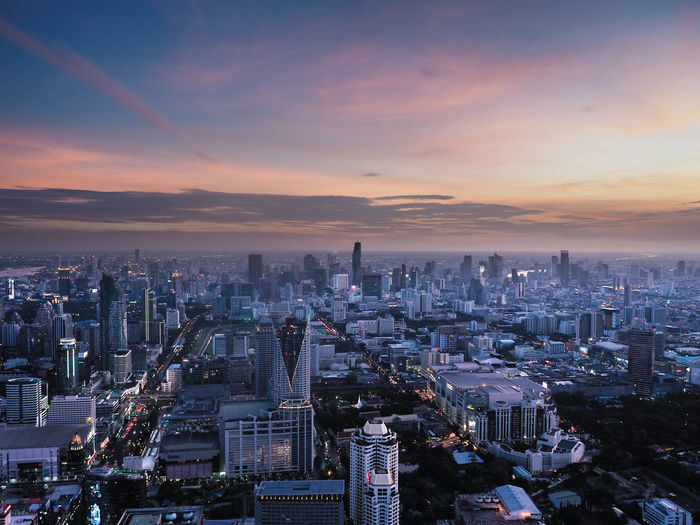 Aerial view of buildings in city against sky during sunset
