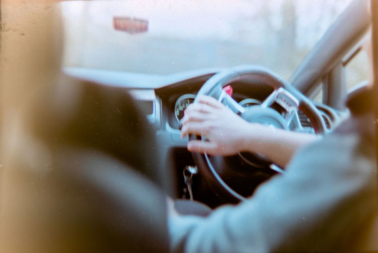 Cropped hands of man driving car