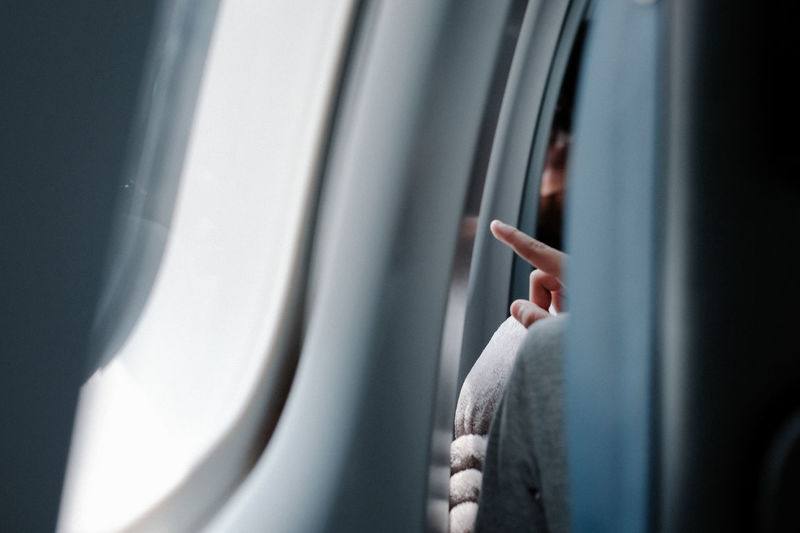 Woman hand by window in airplane