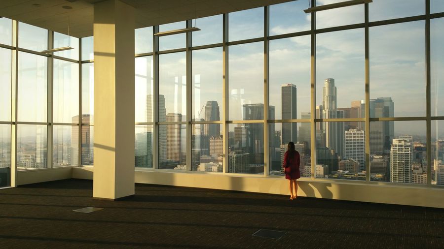 Full length rear view of woman looking at cityscape