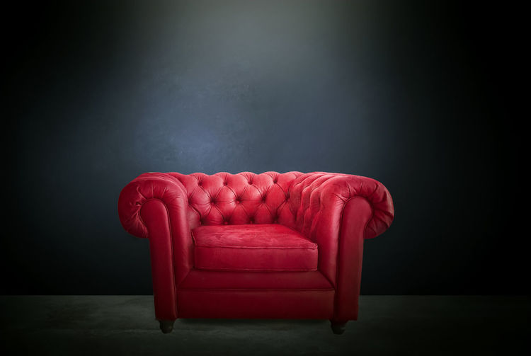 Empty chair against red background