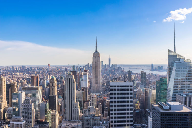 Empire state building amidst cityscape at manhattan