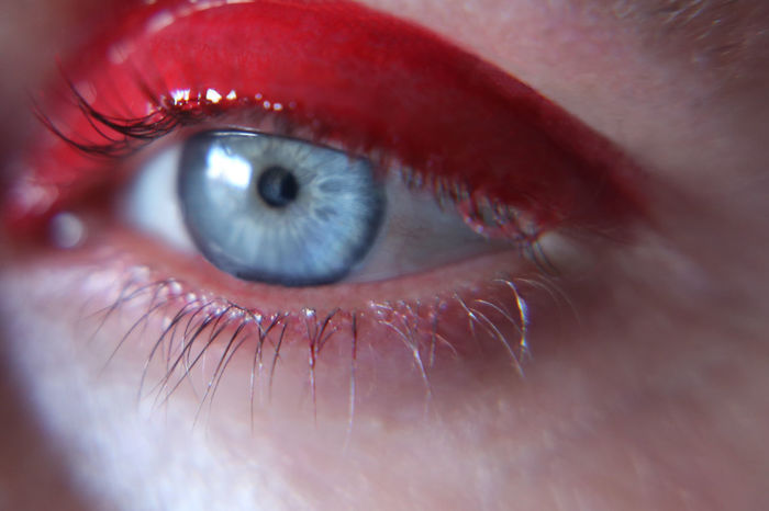 Cropped image of thoughtful woman with red eyeshadow