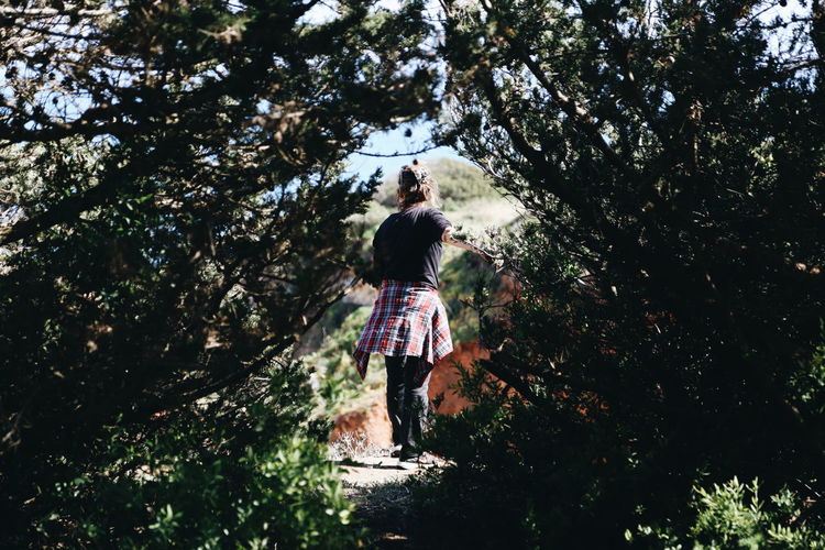 Rear view of girl standing by tree