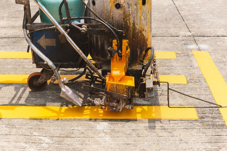 Close up of thermoplastic spray marking machine painting traffic lines on asphalt road