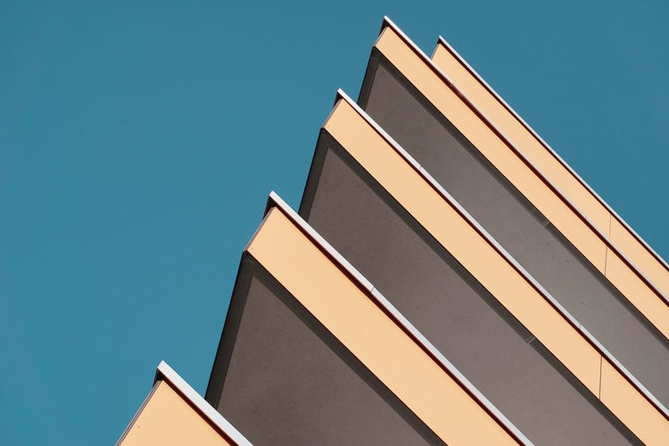 Cropped image of building against clear blue sky