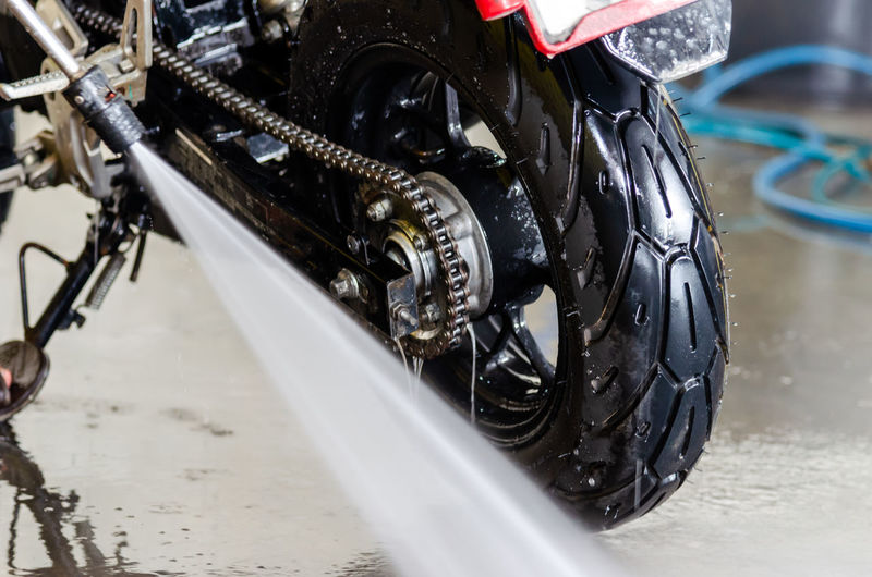 Close-up of water spray cleaning motorcycle tire