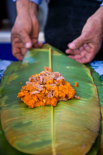 Midsection of man wrapping food in leaf