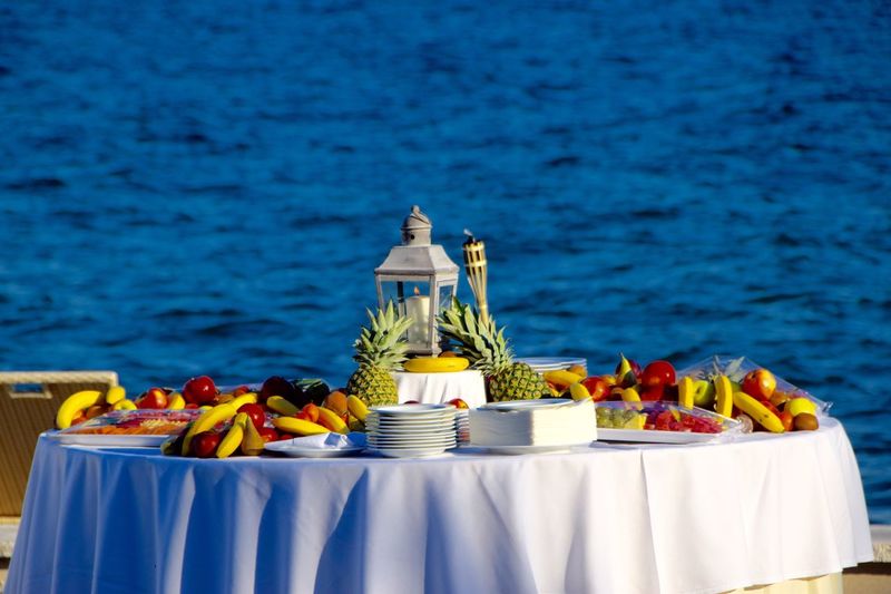 Various fruits on table against blue water