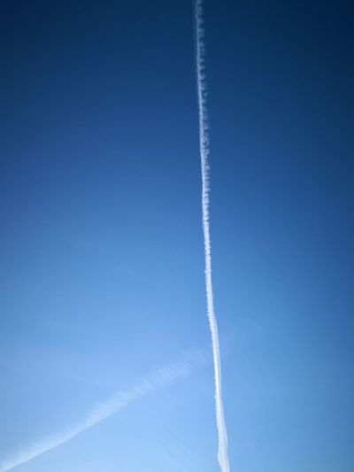 Low angle view of vapor trail against blue sky