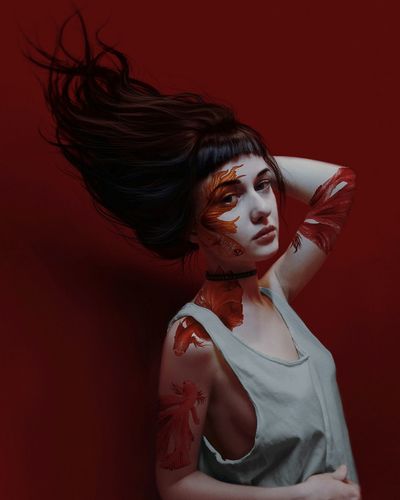 Portrait of woman with body paint against red background