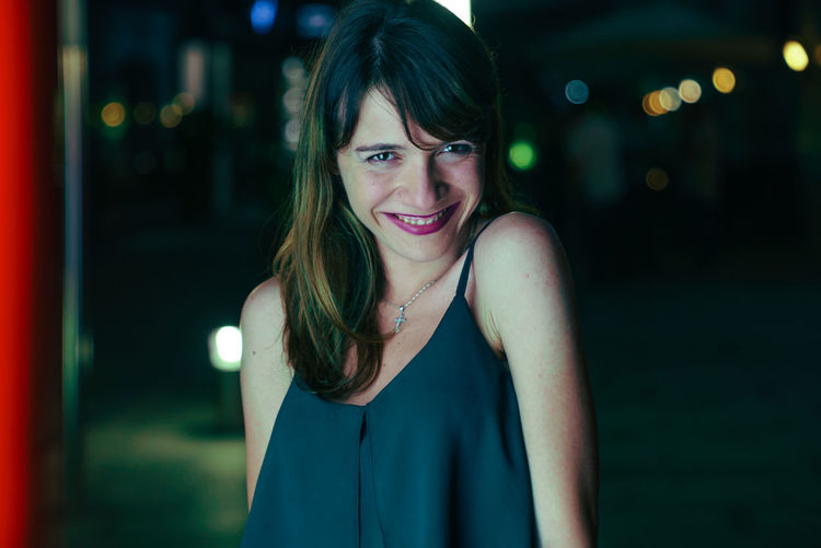 Portrait of smiling young woman at night