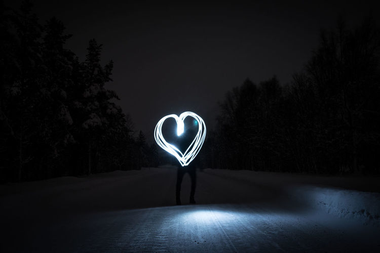 Light-painted heart during night on a lonely road