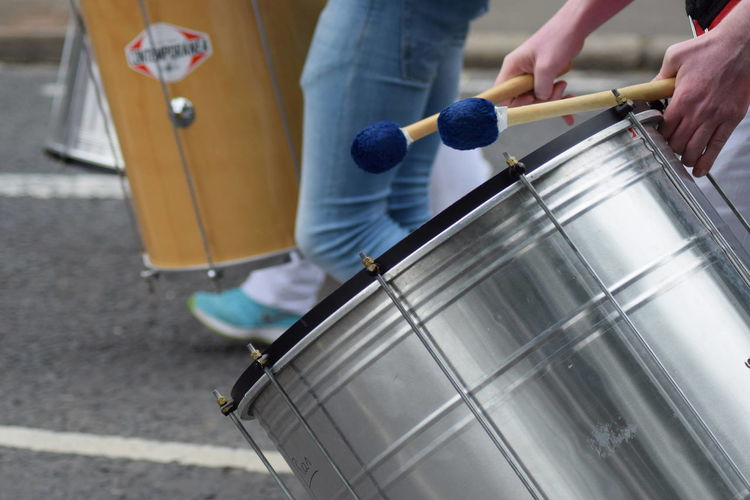 Cropped image of hands playing drum on street