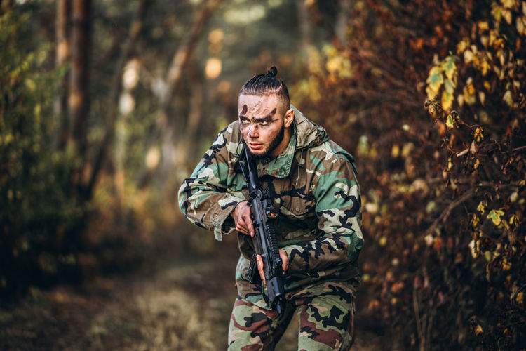 Young woman wearing mask against trees in forest
