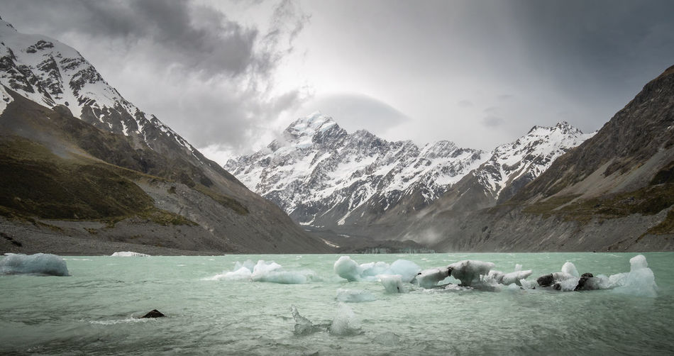 Storm approaching in alpine terrain. glacial lake with pieces of ice. aoraki mt cook np, new zealand