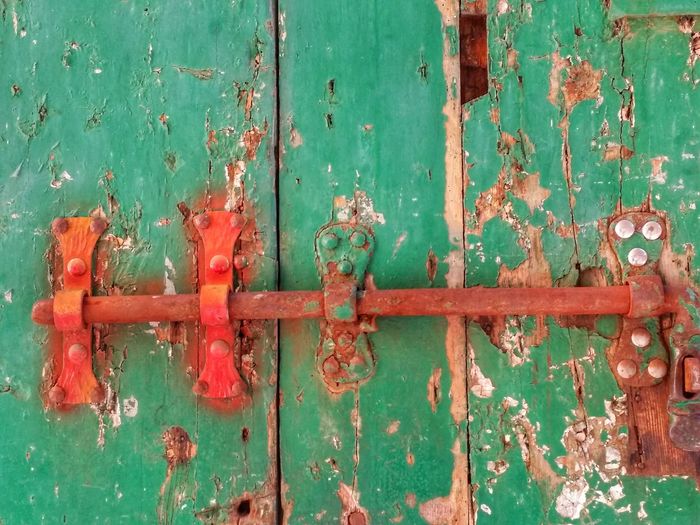Close-up of rusty latch on old wooden door