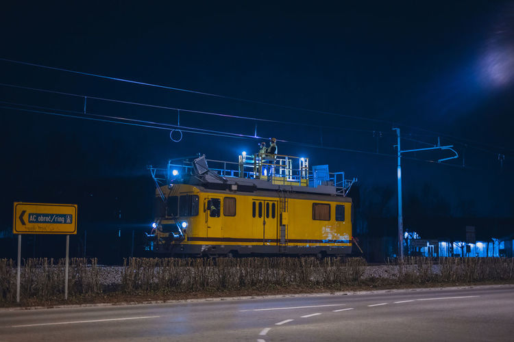Train on road in city against sky at night