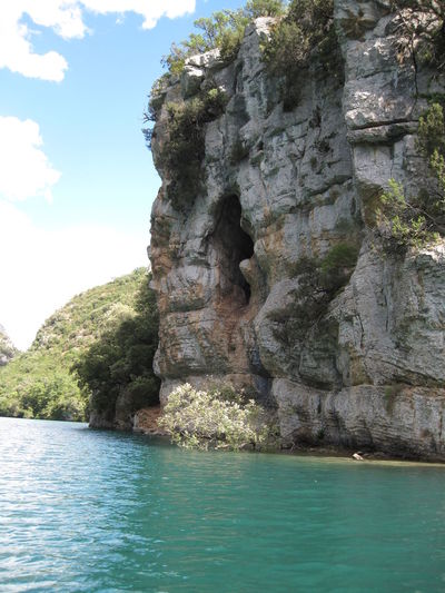 Rock formation by sea against sky