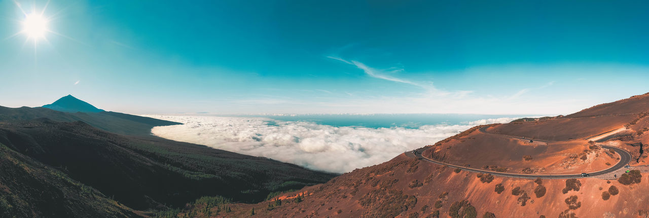Aerial view of road on hill against cloudscape