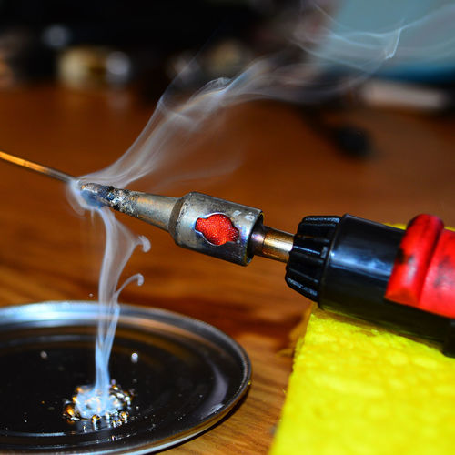 Close-up of soldering iron on table