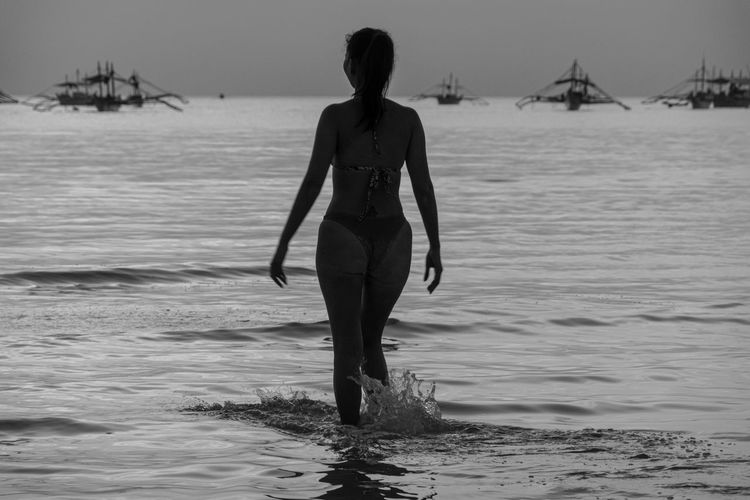 Rear view of woman standing on beach