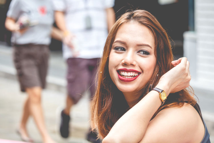 Close-up of happy young woman looking away in city