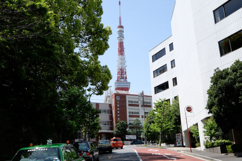 City street by tokyo tower against clear sky