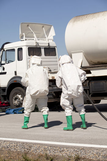 Rear view of workers walking towards vehicle