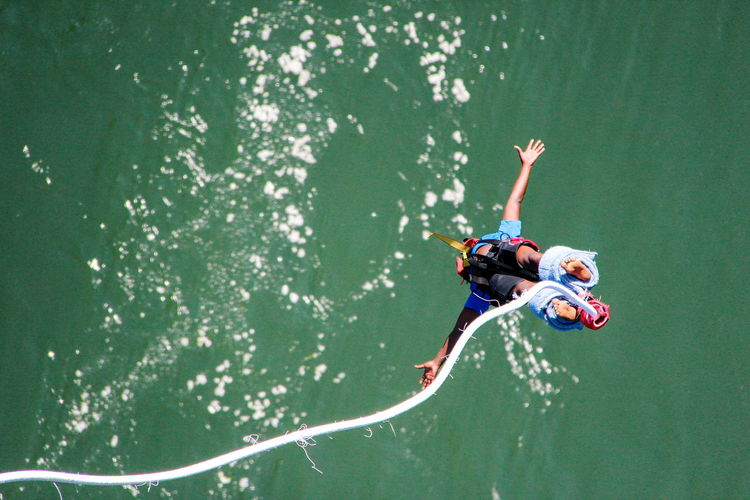 High angle view of man bungee jumping in river
