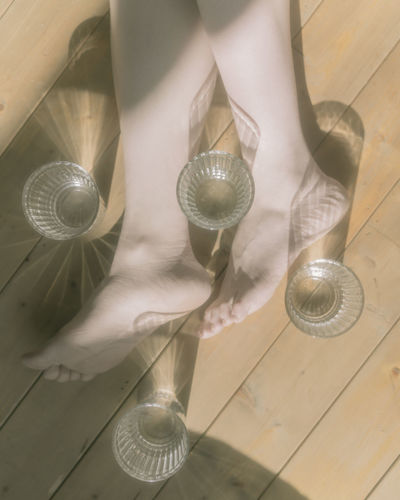Low section of person with glass on table