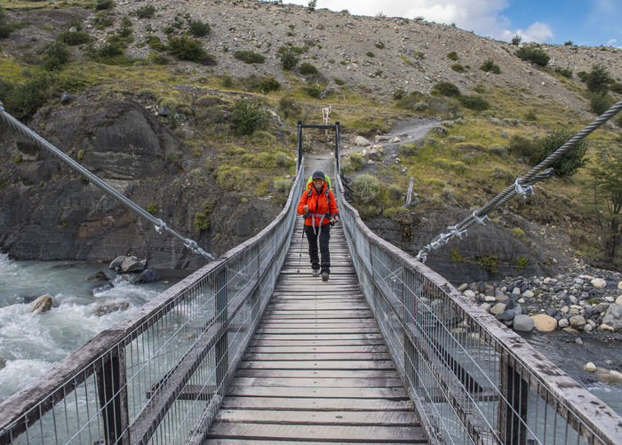 Female hiker crossing bridge at torres del paine national park