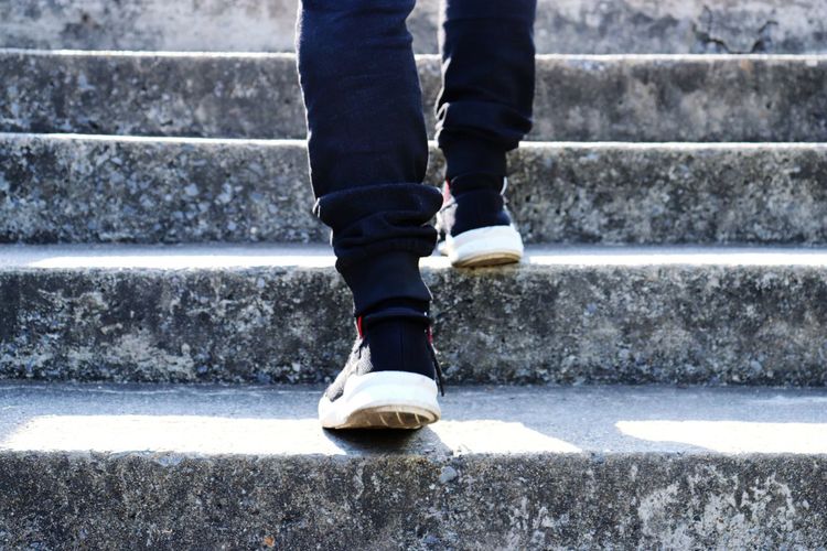 Low section of man standing on staircase
