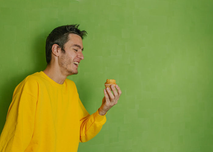 Side view of a man holding yellow leaf