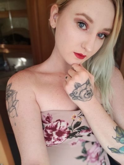 Portrait of young woman with tattoo standing at home