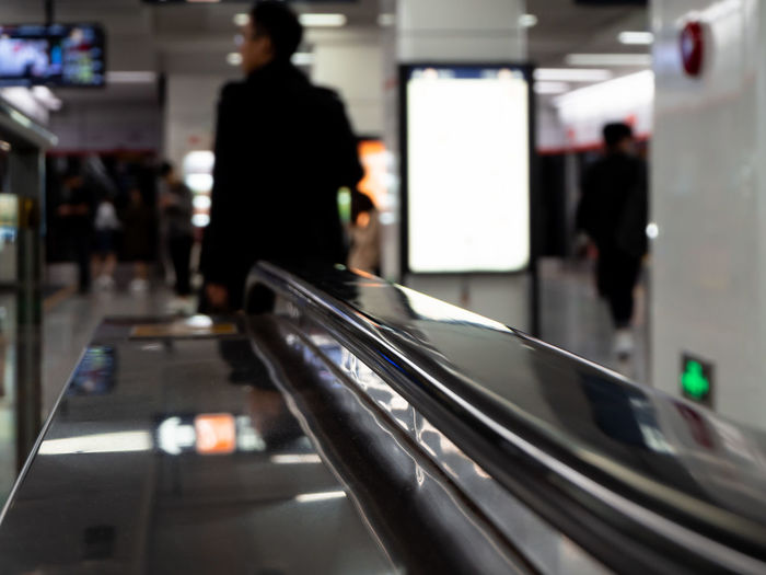 Blurred motion of person walking on escalator