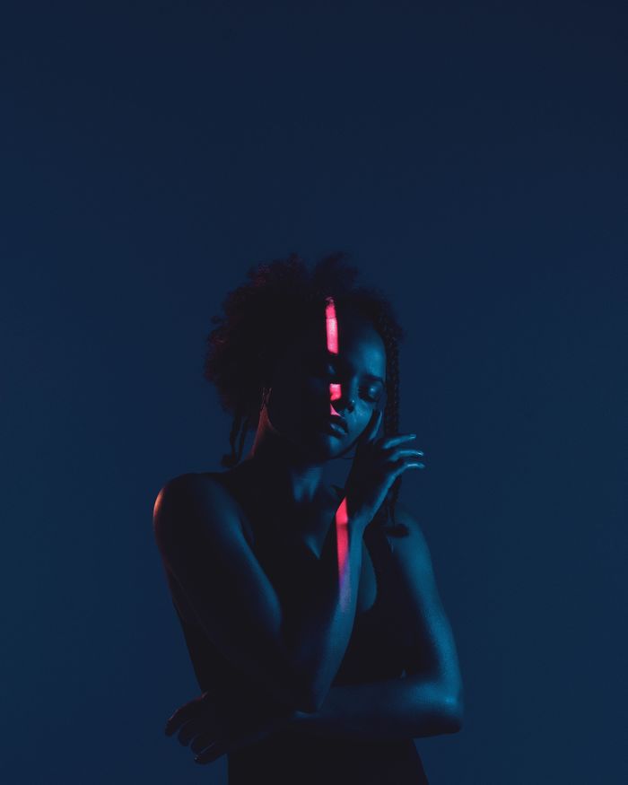 Woman in dark against black background
