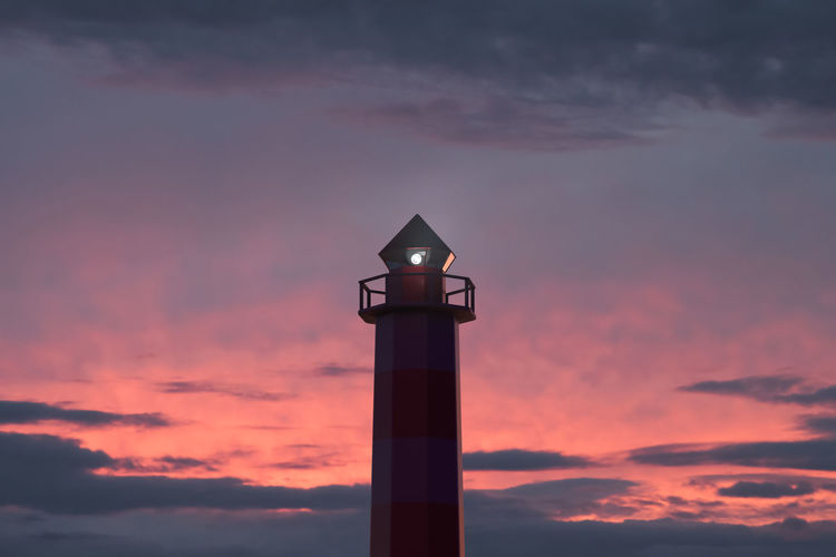 Low angle view of lighthouse against orange sky