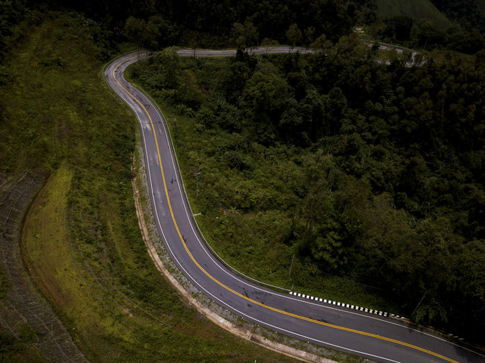 Aerial view of countryside road on the lush greenery tropical rain forest mountain landscape